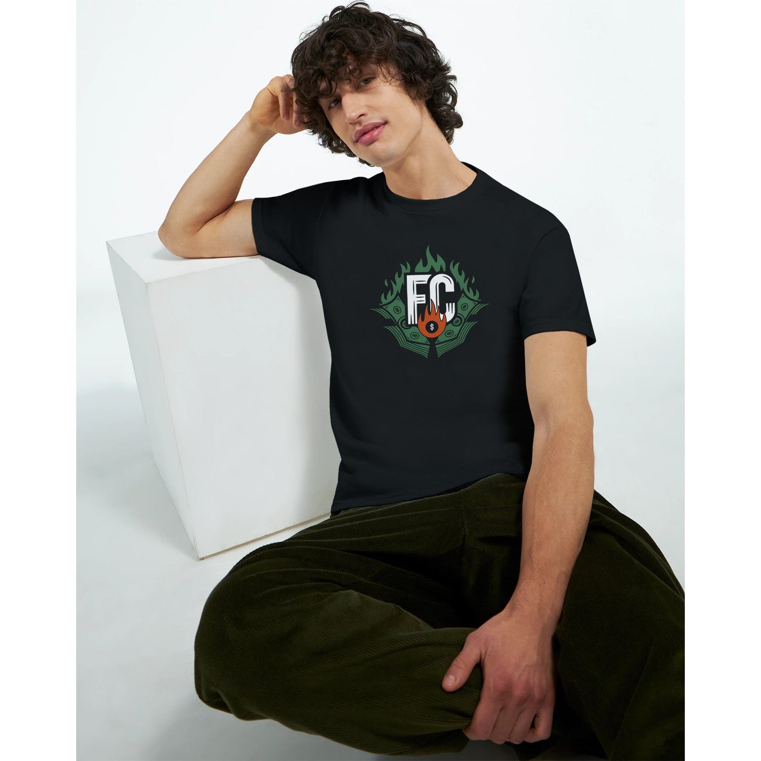 a model sitting on a couch wearing a black t shirt with the free canada logo on it front view